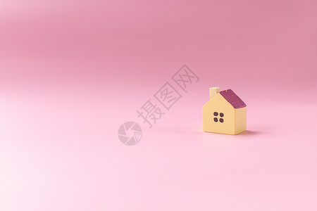 粉红色小房子简单的最小设计 带有在粉红色背景中隔离的微型玩具屋 抵押财产保险梦想家园概念 复制空间金融房地产木头公寓销售建筑学闹钟建造住房经背景