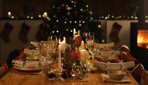 来和我们一起庆祝圣诞节吧 在家里举行家庭圣诞晚餐之前 摆放整齐的餐桌和圣诞树背景图片