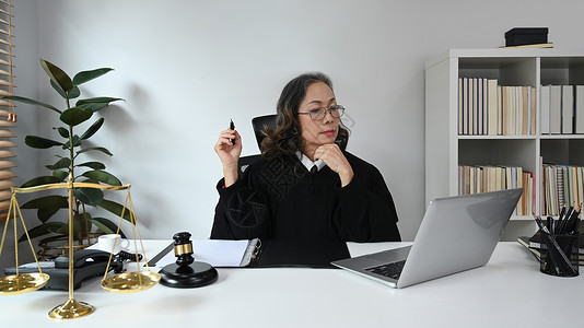 积极成熟的女法官与客户交谈 在线提供法律咨询和法律建议图片