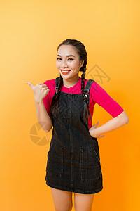 指着某种颜色背景的亚洲女人的肖像女孩手势女性手指微笑产品女士图片