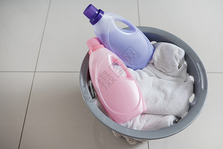 衣物柔顺剂 适合那些洗衣日 让您倍感舒适 一个装满干净衣物和两瓶织物柔软剂的洗衣篮的高角度拍摄背景图片