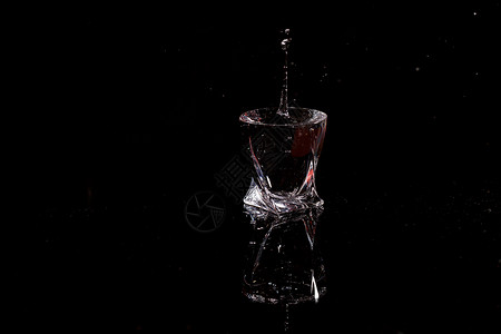 黑色背景是一滴水掉落的玻璃杯 在玻璃上喷洒水艺术雨滴饮料流动反射液体气泡蓝色宏观溪流背景图片