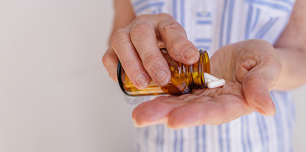 镇痛泵老年妇女将白药从罐子里倒进她的手中 老人的治疗背景