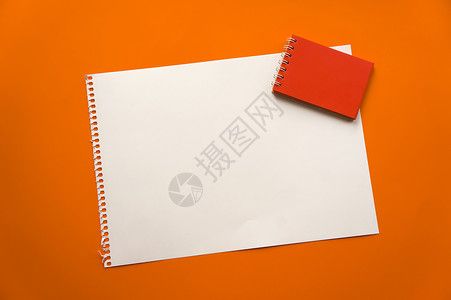 一张空白的纸空间 用于在美丽的橙色背景红色记事本纸上设计和刻字 从记事本上撕下的穿孔纸斜躺在表面上 方形纸热带桌子植物叶子卡片小背景