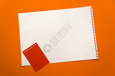 一张空白的纸空间 用于在美丽的橙色背景红色记事本纸上设计和刻字 从记事本上撕下的穿孔纸斜躺在表面上 方形纸床单卡片海报热带植物框背景
