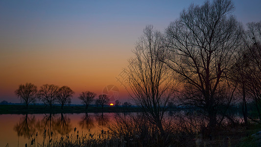 很远春初河上美丽的晚夕日落背景