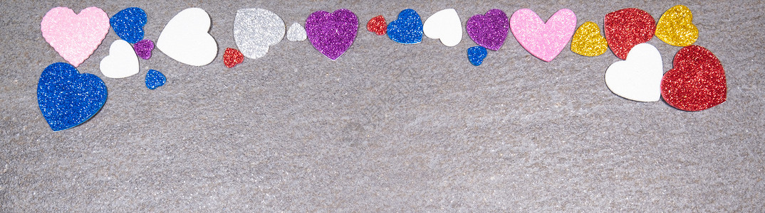 卡心灰色花岗岩背景上所有颜色的闪亮多彩色彩之心 情人节和一般爱的概念背景