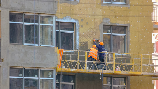 工人正在隔绝建筑物的墙壁高清图片