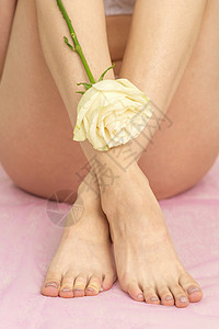 纯素女孩带白玫瑰的女腿脚趾海滩护理长椅皮肤科美容头发卫生身体女性背景