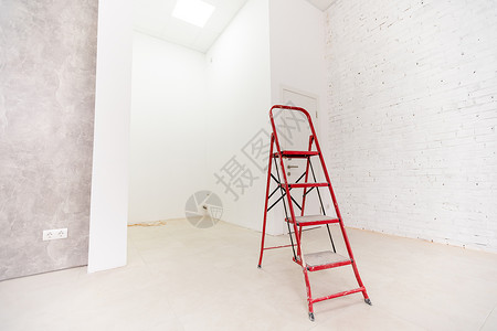 白色梯子翻修期间用梯子在房内油漆墙壁背景