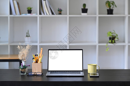 前端电脑膝上型电脑 上面有空显示器 咖啡和木制桌上的铅笔架背景图片