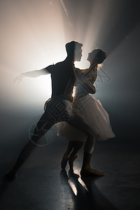 专业的芭蕾舞情侣在大舞台上的聚光灯下跳舞 泛光灯背景下的美丽年轻女子和男子 情感二重唱表演舞蹈艺术音乐夫妻平衡女士优美男性艺术家背景图片