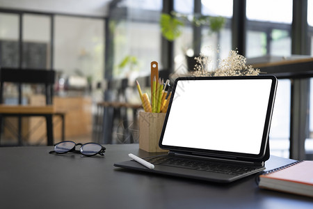 电脑平板 有空白屏幕 眼镜和铅笔架 放在木制桌上背景图片
