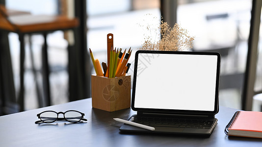 电脑平板电脑 眼镜 笔记本和铅笔架放在木制桌上背景图片