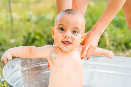 牛奶浴中可爱的 微笑的小男孩肖像 健康的生活方式 夏令营的孩子 自然的概念背景图片