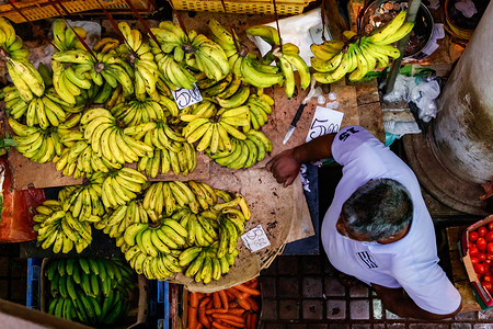 卖家在河内市监督毛里求斯市场大厅的卖家 他正在等待顾客购买成熟的香蕉背景