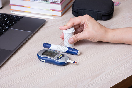 桌子上有血糖仪的女性手 糖尿病患者的生活方式 测量葡萄糖水平控制乐器卫生药品测试疾病手指监视器诊断保健背景图片