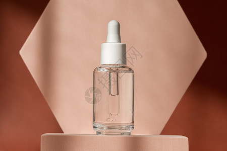 烟酰胺透明质酸 米色讲台基座上的血清护肤瓶 棕色表面有肽和胶原蛋白的化妆品有机血清产品 带有阴影的现代品牌包装背景