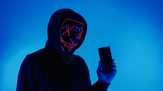 人脸面具数字安全概念 隐形黑客戴着智能手机面具的匿名黑客手指电脑隐私互联网屏幕技术个人数据商务检测背景