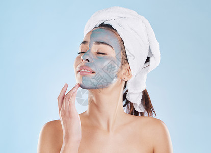 面膜包装样机用于护肤的木炭面膜 用于健康皮肤的美容美容和用于蓝色样机工作室背景的女性身体护理 健康 年轻 冷静的模特用健康产品进行自我护理背景