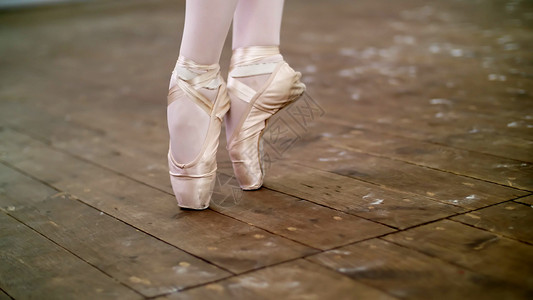 脚趾鞋特写 在舞厅里 芭蕾舞演员表演足尖 她穿着足尖鞋优雅地站在脚趾上 在旧木地板上 在芭蕾课上工作室编舞班级艺术姿势灵活性商店地面学背景