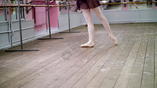 在舞厅里 身穿紫色紧身连衣裤的年轻芭蕾舞演员表演着 她优雅地穿过芭蕾课图片