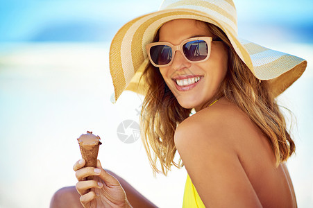 大热天降温 一个美丽的年轻女子在海滩上吃冰淇淋的画像背景