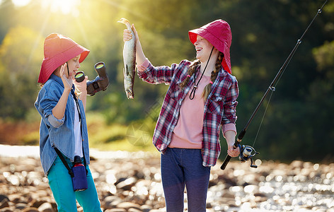 把那东西离我远点 两个年轻女孩在河边钓鱼背景图片