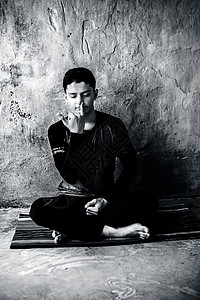 化身瑜伽身穿黑衣服的青春男子在彩色垫子上做Pranayama或pranayam或呼吸控制瑜伽背景