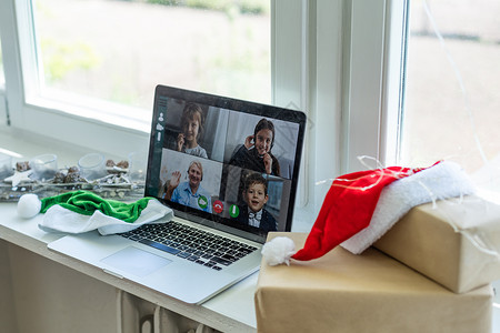 虚拟圣诞节家庭聚会 视频会议 通过家庭办公室的计算机进行视频通话 在线团队礼物开幕式电话会议自由职业者笔记本男人帽子商业工作互联背景图片