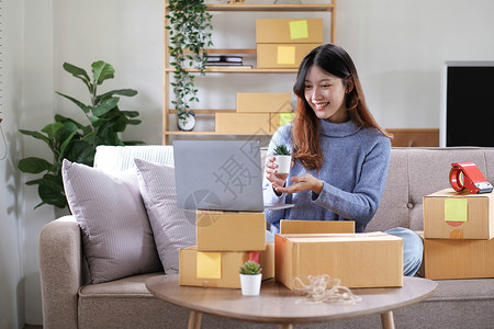 box创业小企业自由职业者 在家办公室工作的肖像年轻女性 BOX 智能手机 笔记本电脑 在线 营销 包装 交付 b2b 中小企业 电子背景