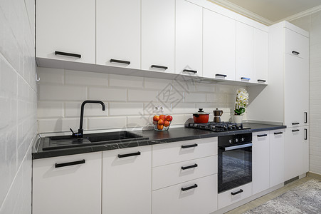 黑色抽屉Trindy 白色的现代厨房室内 内有最起码的家具烤箱房子地面公寓房间橱柜陈列柜装饰水果餐具柜背景