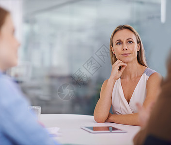 企业集中度 一位年轻的女商务人士专心地听同事讲话图片