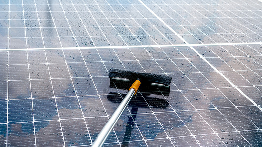 户用光伏在潮湿的屋顶上用超细纤维拖把清洁太阳能电池板 太阳能电池板或光伏组件维护服务 可持续资源 太阳能 绿色能源 可持续发展技术工作生背景