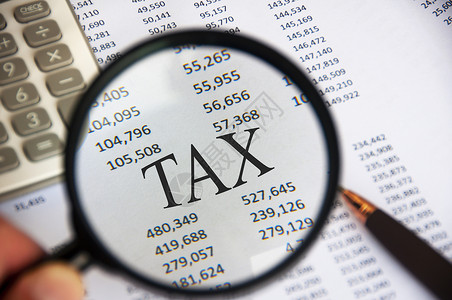 应税侧重于分析纸上TAX字词的放大镜背景