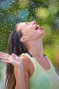 从天而降的雨水 一位年轻女子在滴水时尝到雨水的滋味背景图片