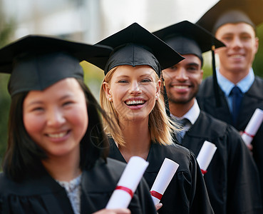 让新的冒险开始 一群大学毕业生站在帽子和礼服上 持有他们的毕业证书 (笑声)背景