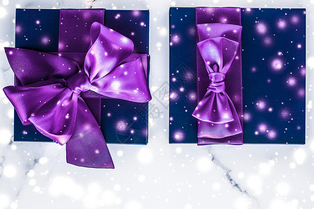 紫色的礼物盒冬季假日礼物盒 带有紫丝弓 大理石背景上的雪亮如圣诞节和新年赠送给豪华美容品牌 平板设计娘娘腔雪花礼物丝绸问候销售推广丝带假期辉背景