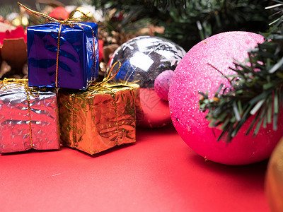礼物盒树圣诞礼物盒 以不同颜色包裹在圣诞节树下红色背景的圣诞树上问候语季节假期卡片庆典绿色浆果传统木板礼物背景