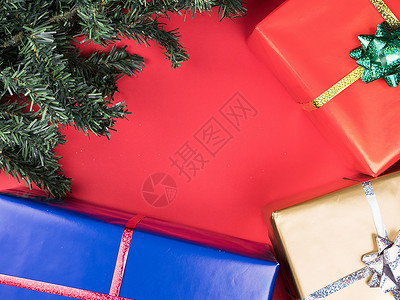 圣诞礼物盒和红背景的圣诞节圣诞树红底传统卡片问候语红色丝带装饰品季节绿色庆典装饰背景图片