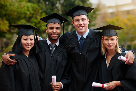 资质申报艰难的道路往往通向美丽的目的地 一群大学毕业生戴着帽子和长袍 拿着他们的文凭背景