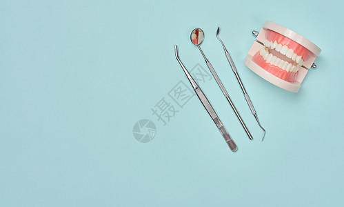 带有白牙甚至牙齿和体格检查镜的塑料型人下巴塑性模型 tweezers背景图片