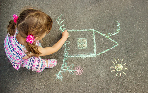 心中有梦孩子用沥青上的粉笔画房子 有选择的焦点学校太阳乐趣创造力幸福艺术女孩幼儿园铅笔婴儿背景