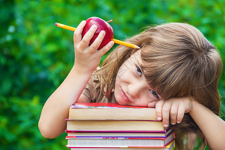 苹果女孩有红苹果的小女孩学生 有选择的焦点 大自然瞳孔游戏教训学习家庭作业女孩电话铅笔女性婴儿背景