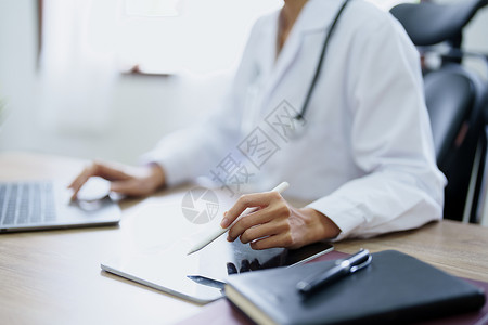电脑可访问一名使用计算机和平板电脑工作的亚洲女医生的肖像检查病人处方会议医院顾问内阁药品心理治疗商业背景