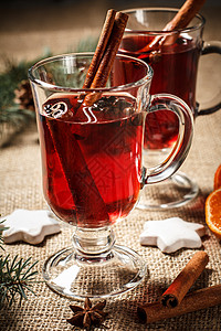 热葡萄酒一杯圣诞美酒 配香料 橙子和涂着麻布的饼干星星八角芳香食物木头假期肉桂饮料玻璃杯子背景