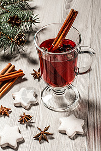 一杯圣诞美酒 木板上加香料和饼干的庆典杯子星星假期木头八角调色饮料肉桂水果背景图片
