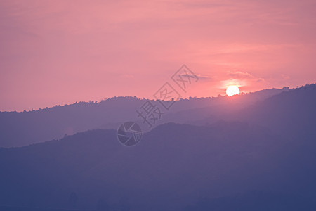 美丽的山脉风景 粉红色的面朝日落天空 背景是山丘图片