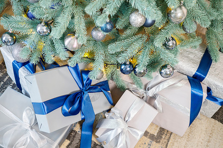 圣诞树上装饰着玩具和园地 下面有礼品 在树下摆放圣诞礼物房子花环壁炉盒子金子装饰品丝带礼物展示松树背景图片