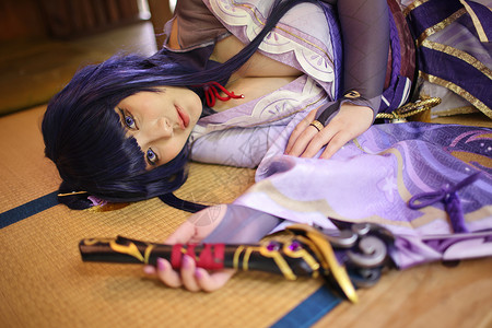 一个美丽的年轻女子游戏的肖像 和睡在日本房间的武士服装装扮一起玩背景图片